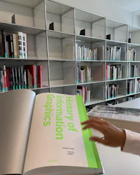 a woman looking at a book in a library