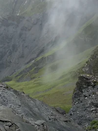 a man is walking down a rocky path in the mountains